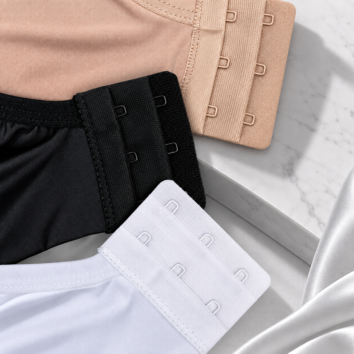Detalhe dos fechos de colchetes dos sutiãs Bellalace nas cores bege, preto e branco