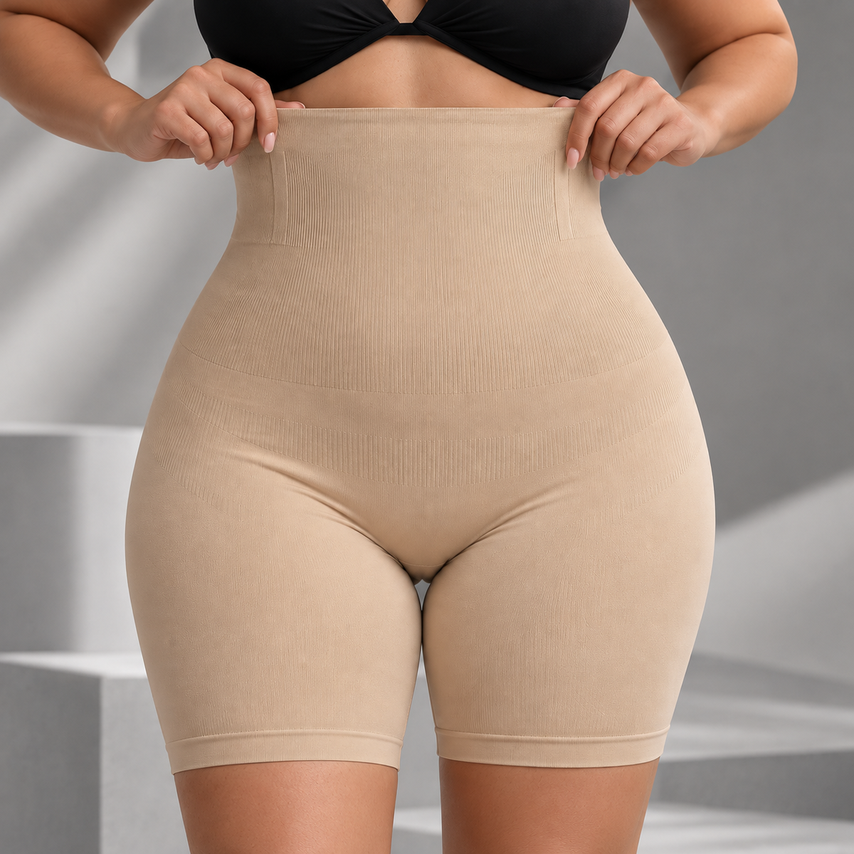 Short modelador Bellaform bege vestido de frente, com o cós alto puxado pelas mãos